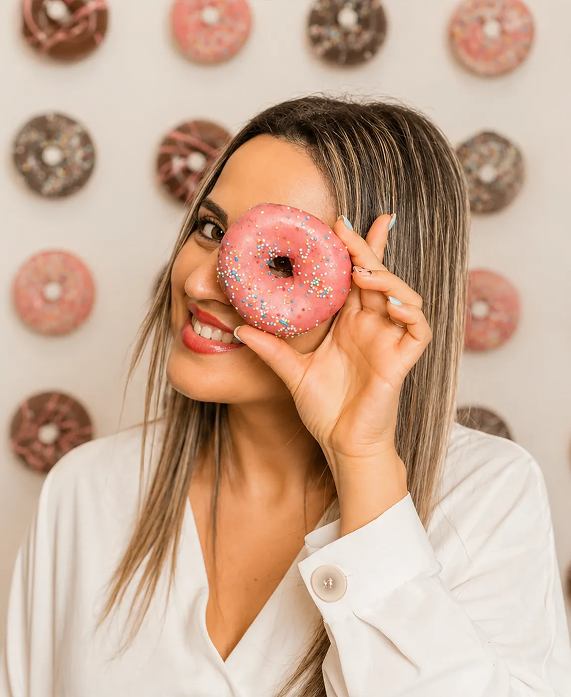 Marta, fundadora de La Postrería de Marta, posando con un donut artesanal en Sanxenxo